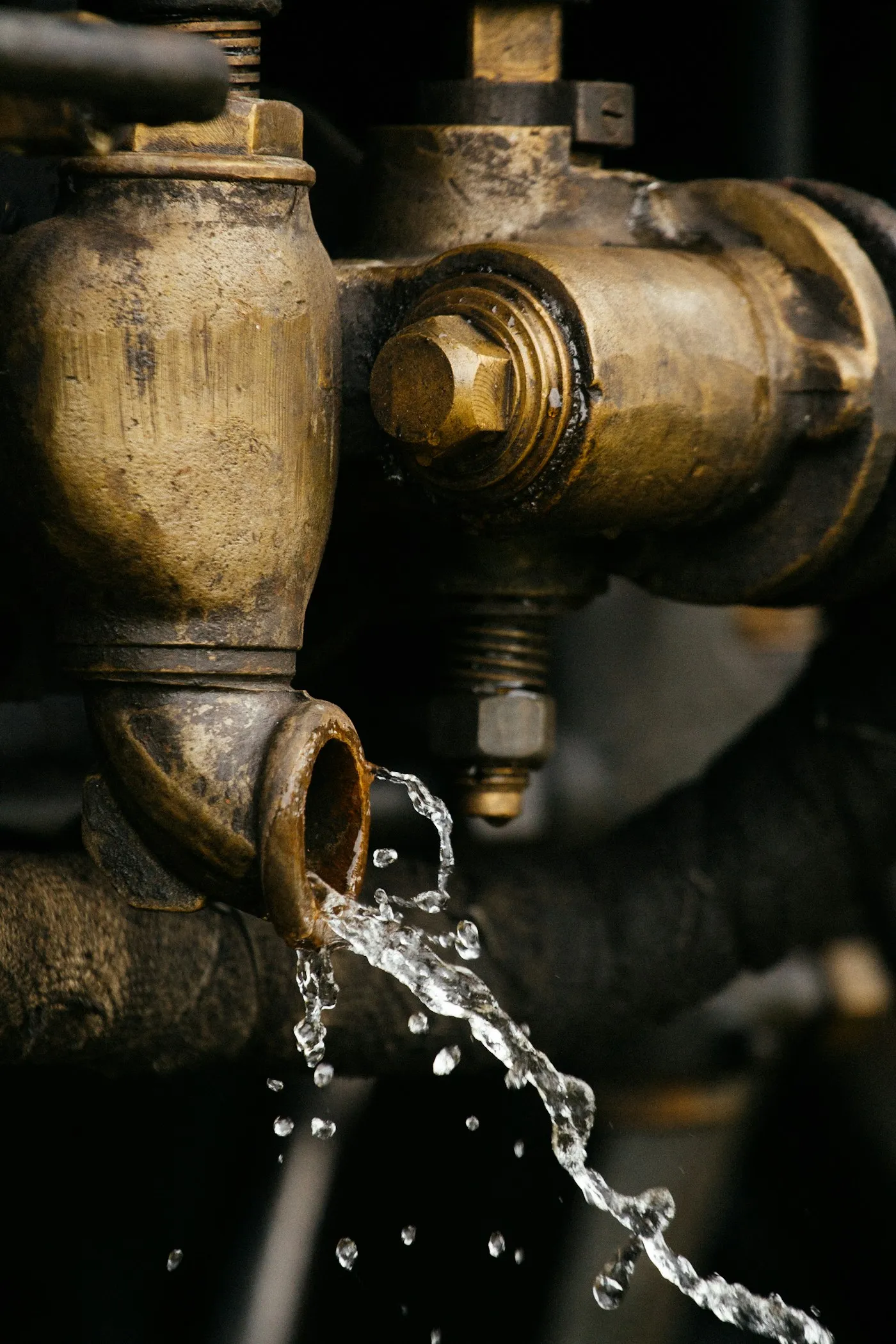 Close-up of a brass valve with water running from it