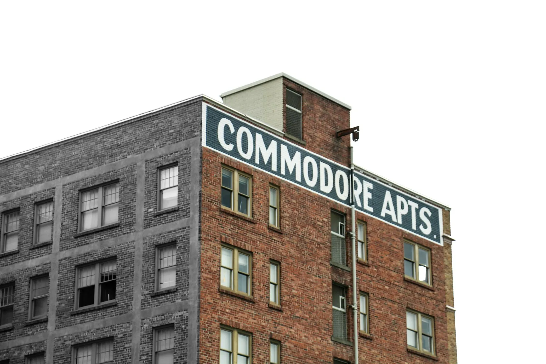 A brick apartment building under a white sky
