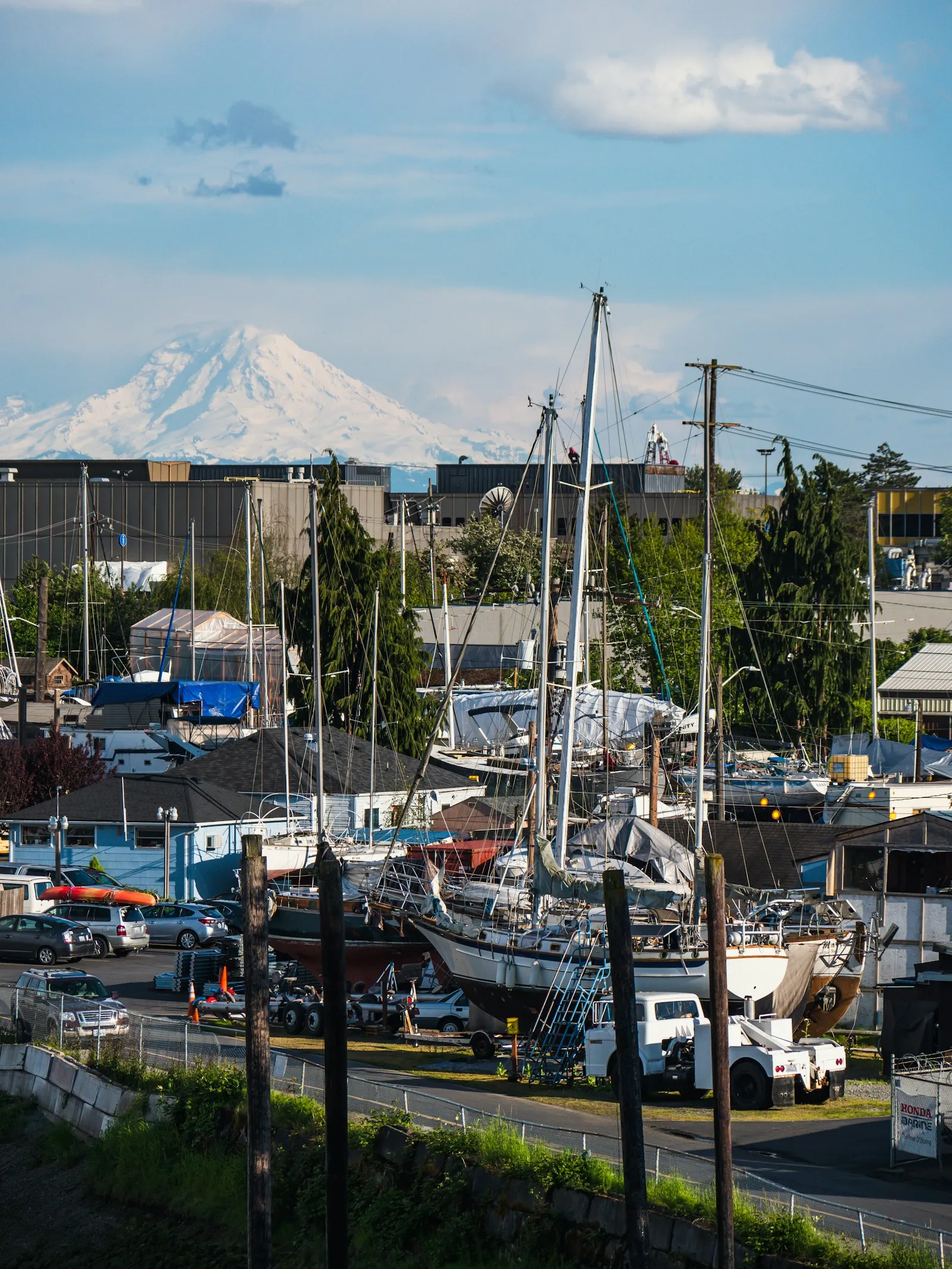 Sailboats in a working marina with snow-covered Mount Rainier in the distance