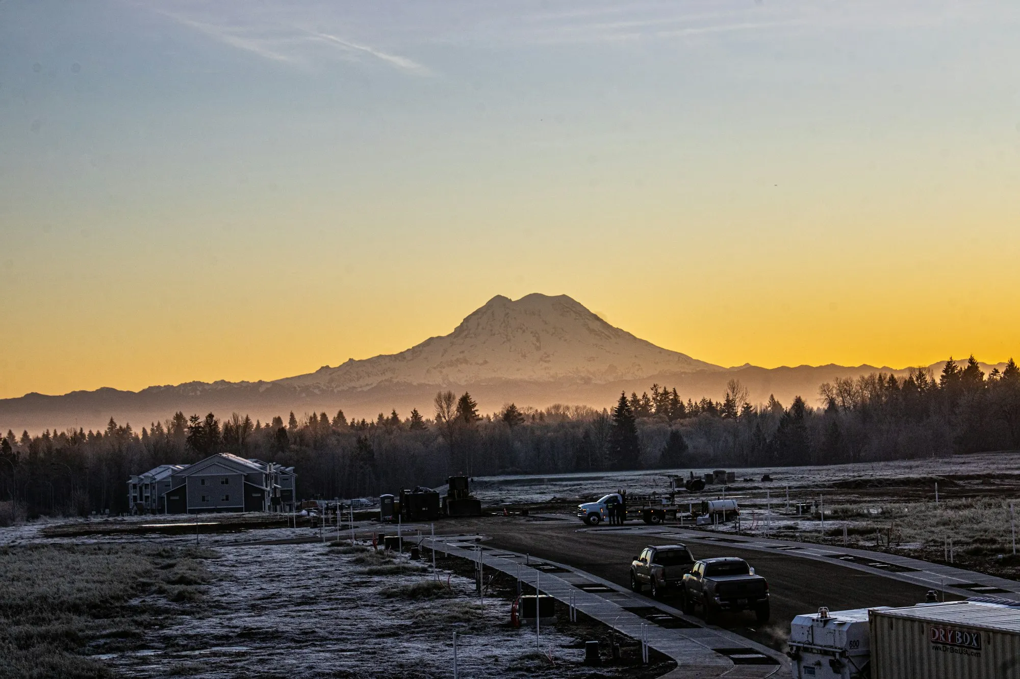 Mount Rainier at sunset above an industrial yard
